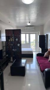 a living room with a bed and a couch at SMDC Tagaytay Condominium in Kaybagal