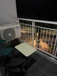 a balcony with a table and chairs and a heater at SMDC Tagaytay Condominium in Kaybagal