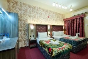 a hotel room with two beds and a bathroom at Quality Hotel Apartments in Sabkhah
