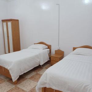 two beds in a room with white sheets at أسطورة السلطانية للشقق المخدومة درجة اقتصادية in Abha