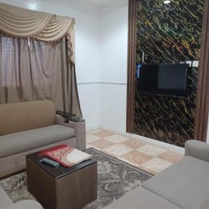 a living room with a couch and a tv at أسطورة السلطانية للشقق المخدومة درجة اقتصادية in Abha