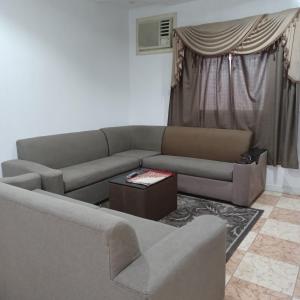 a living room with a couch and a table at أسطورة السلطانية للشقق المخدومة درجة اقتصادية in Abha