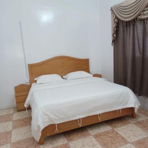 a bedroom with a large bed with white sheets at أسطورة السلطانية للشقق المخدومة درجة اقتصادية in Abha