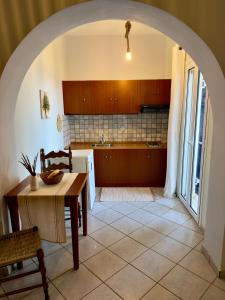 an archway in a kitchen with a table and a sink at Natasa studios Kythera in Kythira