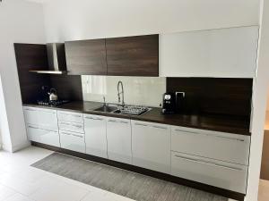 a kitchen with white cabinets and a sink at AragonApartment in Santa Maria a Vico +20 photos