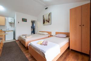 a room with two beds and a kitchen at M Group Studios in Tivat