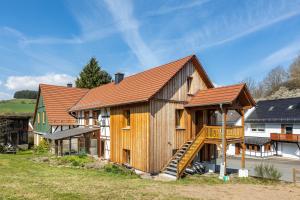 a large wooden house with a staircase in front of it at Ferienwohnung am Bertenberg -Keßler in Diemelsee