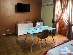 a room with a table and a bed and a tv at Via Gagliardi - Centro in Vibo Valentia
