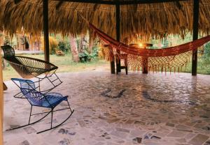 two chairs and a hammock in a tent at Pomelo Hostal in Mingueo