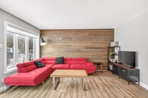 a living room with a red couch and a tv at Hameau 33-104 in Stoneham