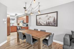 a kitchen and dining room with a wooden table and chairs at Hameau 33-104 in Stoneham