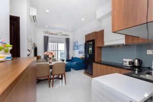 a kitchen and living room with a blue couch at Mermaid-Oasky-50m to ThápTamThắng&Biển in Vung Tau