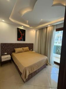 a bedroom with a bed and a large window at Sharm Hills Resort - 2Bedroom with Pool View and Beach Access in Sharm El Sheikh +73 photos
