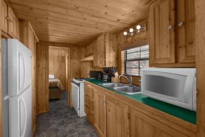 a kitchen with a sink and a microwave at Sun Outdoors Canyonlands Gateway in Moab