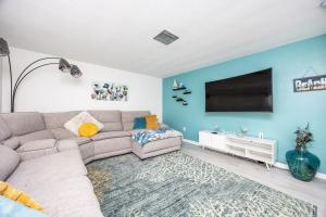 ein Wohnzimmer mit Sofa und Flachbildfernseher in der Unterkunft Sol Vacation in Largo