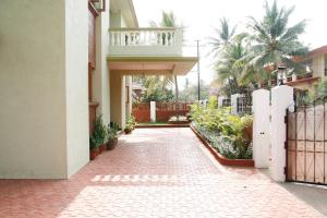 a brick walkway leading to a house with a balcony at KD's Villa - North Goa in Porvorim