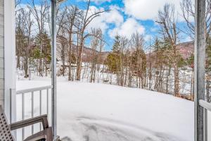 a snow covered yard with a fence and trees at Hameau 33-104 in Stoneham