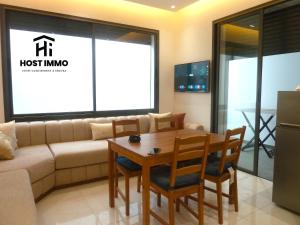 a living room with a couch and a table and chairs at Apartment - Mehdia Beach in Kenitra