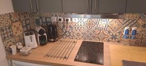 a kitchen counter with a cutting board and a tile wall at Studio calme proche de Nice in Colomars