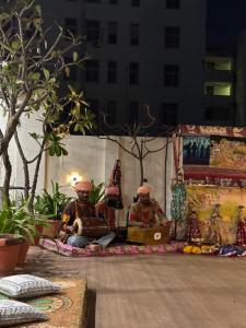 two figurines of two men sitting on a rug at Joey's Hostel Jaipur in Jaipur