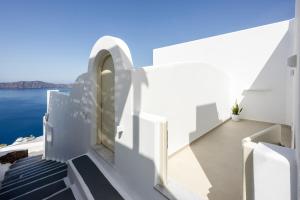 a white house with a view of the water at Caldera Jewel Santorini in Firostefani
