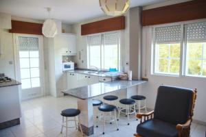 a kitchen with a large island with bar stools at Apartamentos Avenida Areas II in Sanxenxo