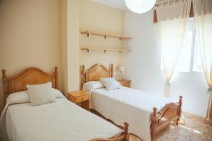 a bedroom with two beds and a window at Apartamentos Avenida Areas II in Sanxenxo +13 photos
