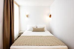 a bed in a room with a window at Caldera Jewel Santorini in Firostefani