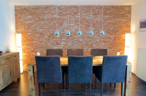 a dining room table with chairs and a brick wall at mönchgut living & spa in Gager