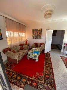 a living room with a couch and a red rug at Yamna home in Agadir