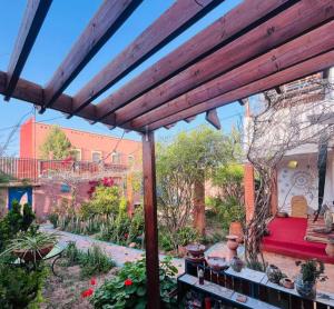 a patio with a red couch in a garden at Yamna home in Agadir