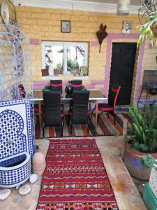 a room with a table and chairs and a rug at Yamna home in Agadir