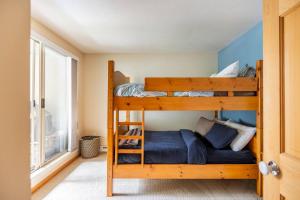 a bedroom with two bunk beds and a window at 31GlenEagle Whistler in Whistler +45 photos