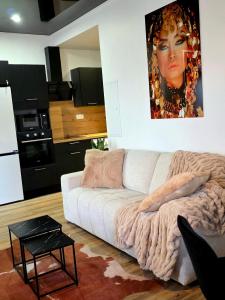 a living room with a white couch and a painting on the wall at Le Joyau du lac in Charavines