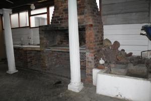 a brick fireplace in a room with a pillar at Tatami Guesthouse in Parow