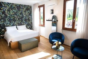 a bedroom with a bed and two blue chairs at DEL CARMINE AGRIRESORT- ex a3passi in Ancona +73 photos