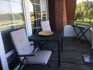 a balcony with two chairs and a table and a table at NTBM36104-FeWo-Swalkennest in Neue Tiefe Fehmarn