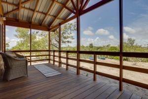 a screened in porch with a chair on a wooden deck at Tortuga Amarilla 1 in Maya Beach
