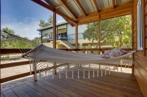 a hammock on the porch of a house at Tortuga Amarilla 1 in Maya Beach