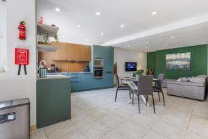 a kitchen and living room with a table and chairs at Bright 3BR Penthouse with Pool & BBQ in Msida by QuickTrips in Misraħ Il-Barrieri