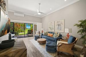 a living room with a blue couch and chairs at Beachfront Lae Nani 3BD Condo AC & Heated Pool in Kapaa