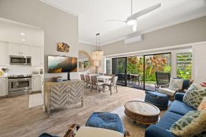 a living room with a blue couch and a table at Beachfront Lae Nani 3BD Condo AC & Heated Pool in Kapaa