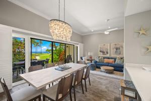 a dining room and living room with a table and chairs at Beachfront Lae Nani 3BD Condo AC & Heated Pool in Kapaa