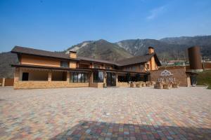 a large house with a brick driveway in front of it at By Tau in Almaty