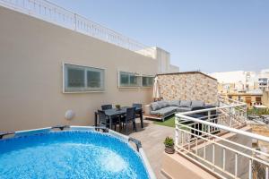 a balcony with a swimming pool on a building at Bright 3BR Penthouse with Pool & BBQ in Msida by QuickTrips in Misraħ Il-Barrieri