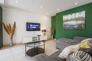 a living room with a couch and a flat screen tv at Bright 3BR Penthouse with Pool & BBQ in Msida by QuickTrips in Misraħ Il-Barrieri