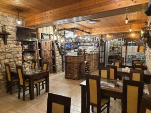 a restaurant with tables and chairs and a bar at Guest House Iljesa in Berat