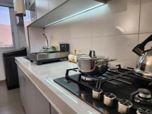a kitchen with a stove with pots and pans on it at Acogedor Refugio en Tacna in Tacna +6 photos