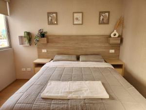 a bedroom with a large bed with a wooden headboard at Acogedor Refugio en Tacna in Tacna