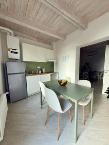 a kitchen and dining room with a green table and chairs at La Dimora Di Roberta in Montalcino